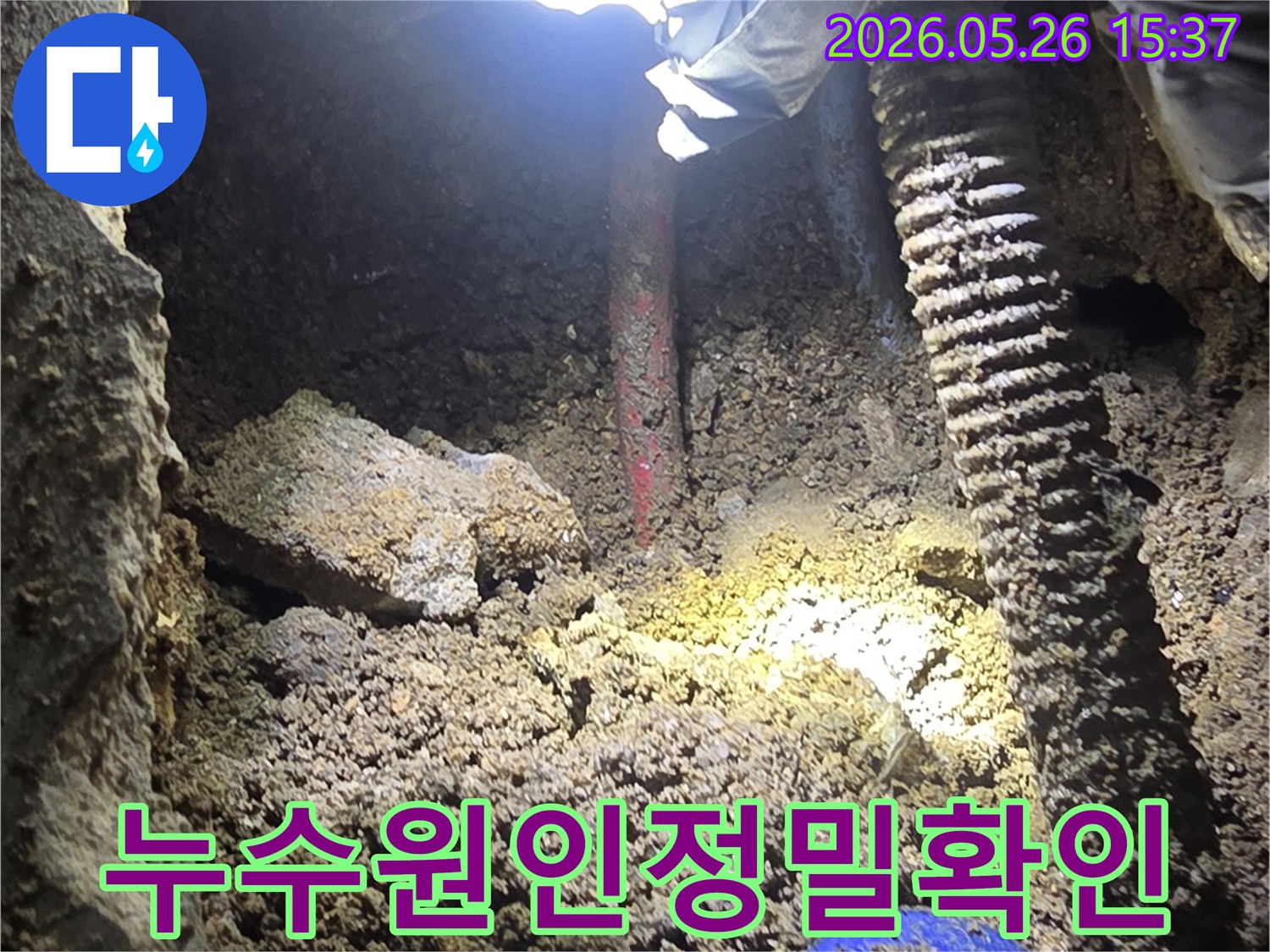 누수-탐지-전문가가-어두운-굴착-현장에서-배관의-미세한-누수-지점을-손전등으로-밝혀-확인하는-모습
