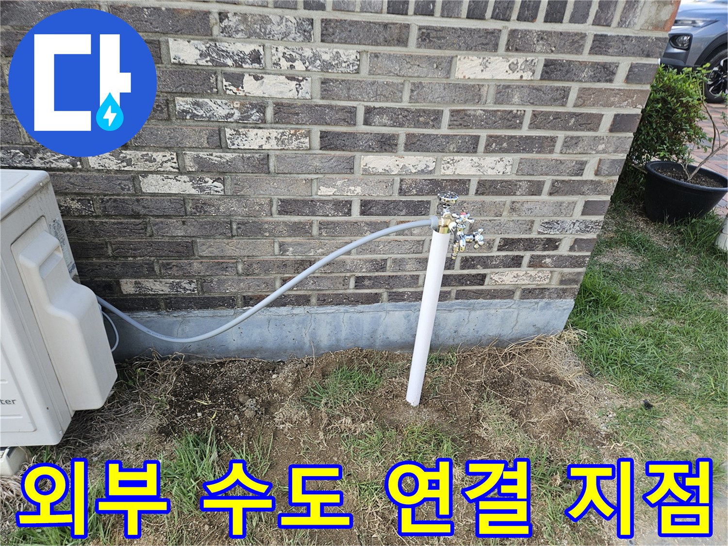 벽돌 외벽에 설치된 수도꼭지와 연결 호스 모습