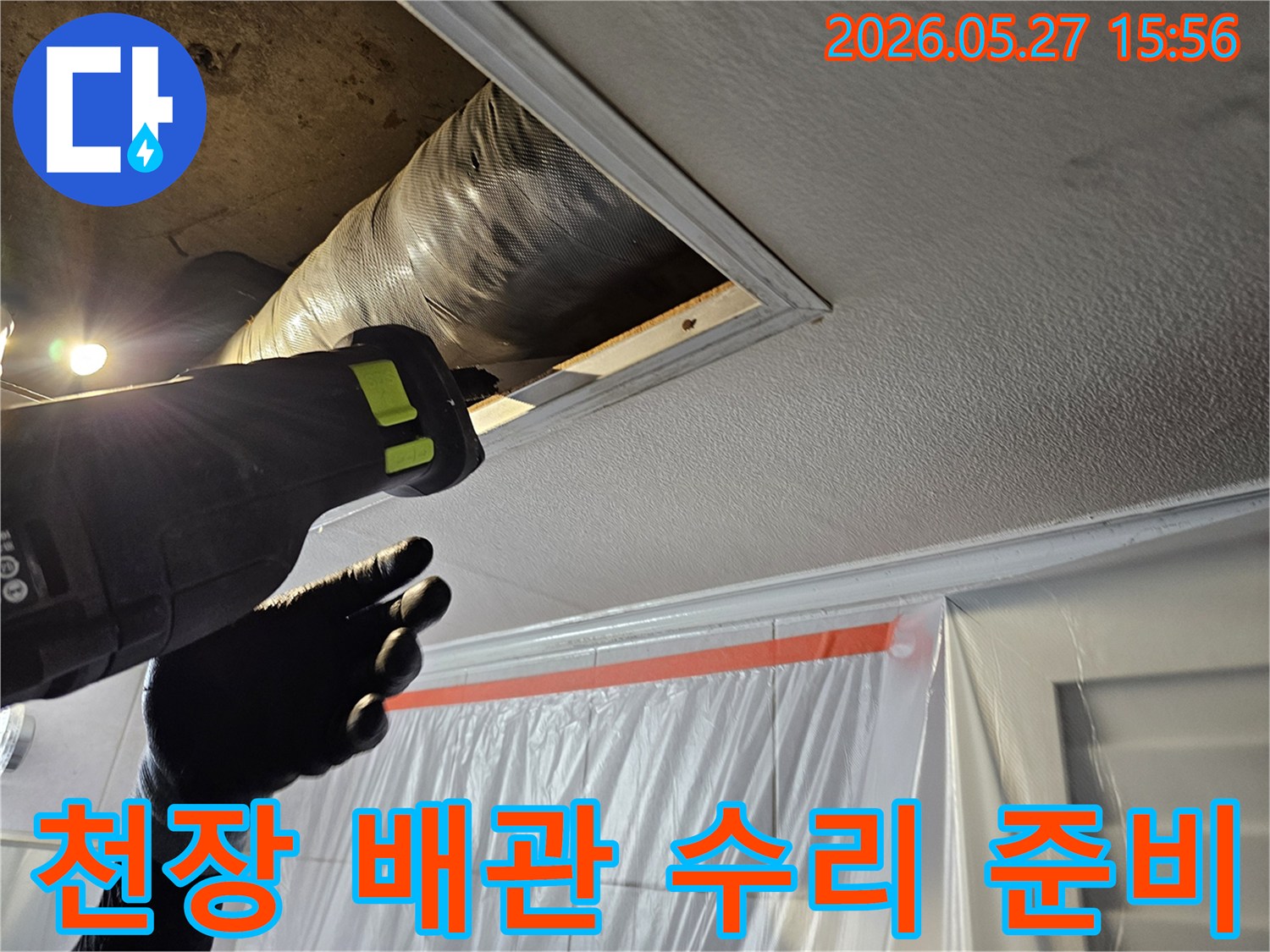 누수-전문가가-천장-배관-수리를-위해-작업-공간을-확보하는-장면