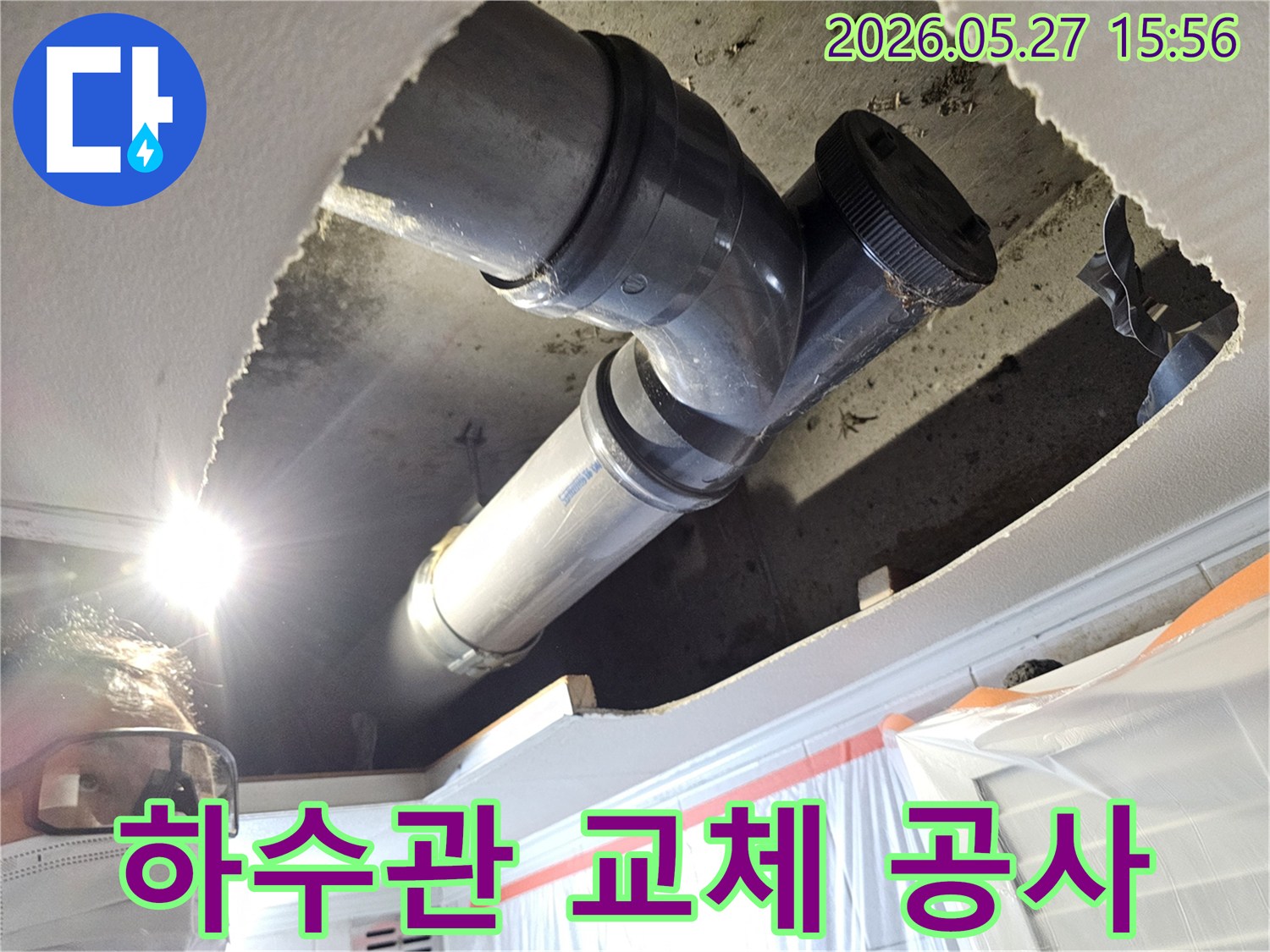 주택 천장 내부의 노후된 하수관을-새로운 배관으로 교체하기 위한 작업 현장