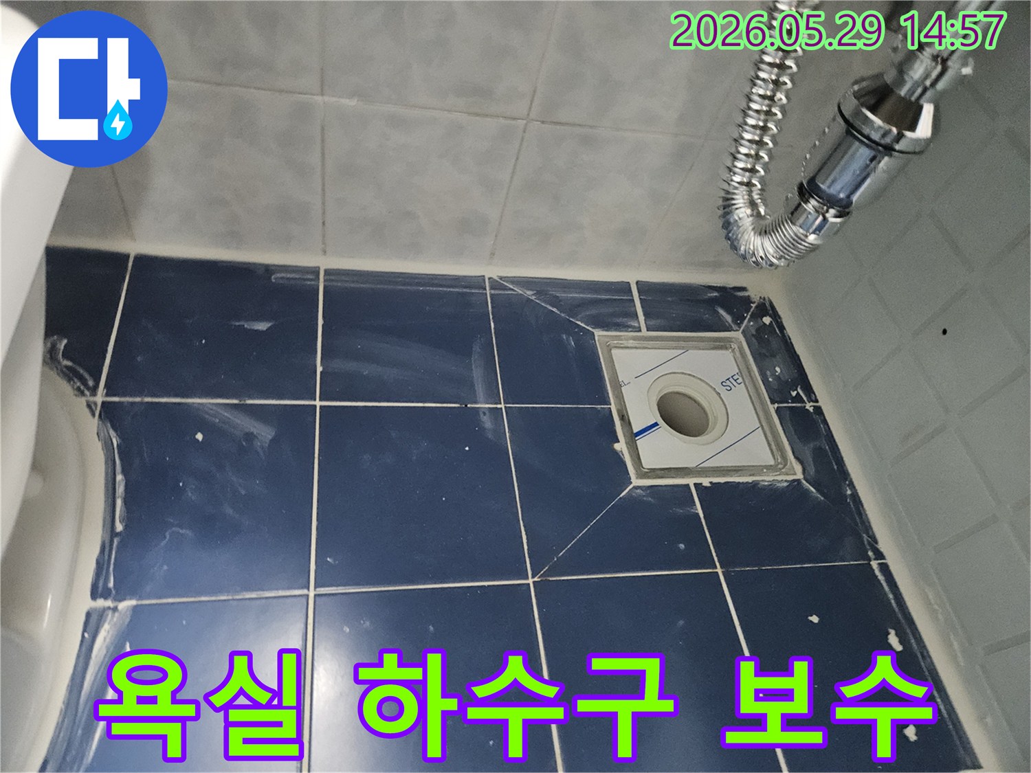 욕실 바닥의-새로운 배수구와-주변 타일-그리고 견고하게-연결된 유연한-배수관이-보이는-하수구-누수-보수-현장-사진입니다