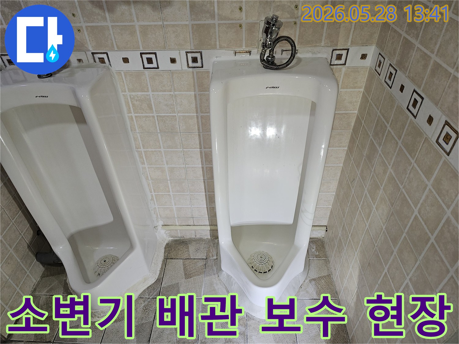 공용 화장실 소변기 배관 연결부에서-누수가 발생하여-전문가가 보수 작업을 진행하는 모습입니다.