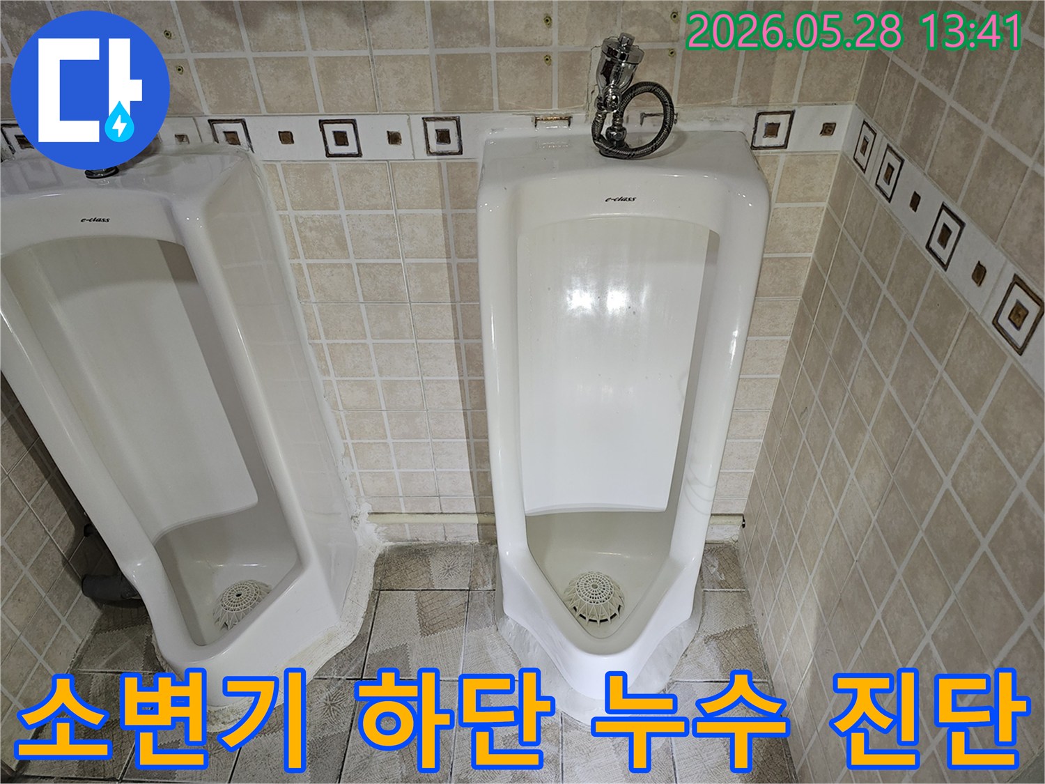 공용 화장실 소변기 하단에서 발생한 누수를-전문가가 육안으로 정밀하게 진단하고 있는 모습입니다.