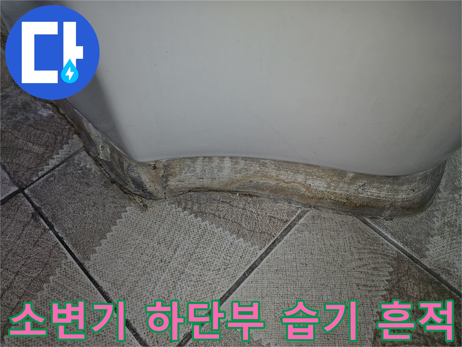 소변기 밑부분-누수로 인해 젖어 있는 타일 경계선