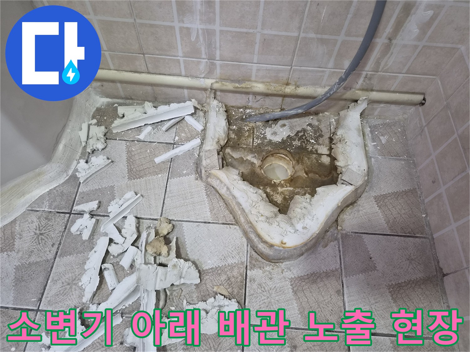 소변기를 제거한 후 드러난 젖은 바닥과 배관 연결부