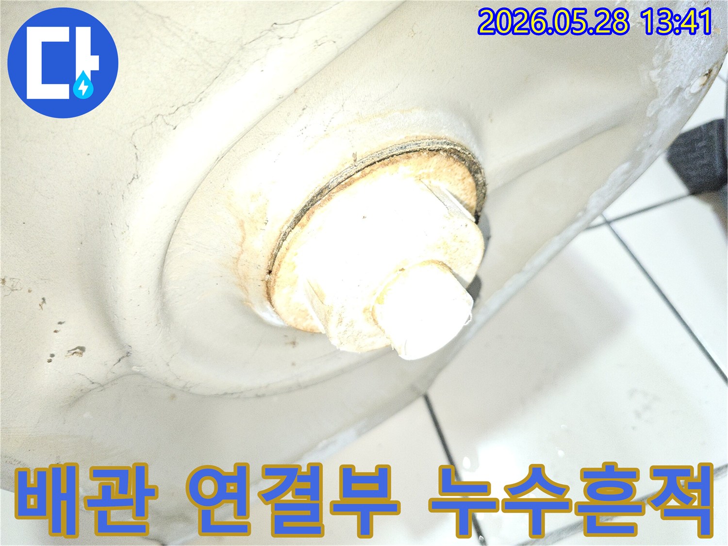 이 사진은 오래된 배관 연결부에서 발생한 누수 흔적을-자세히 보여줍니다
