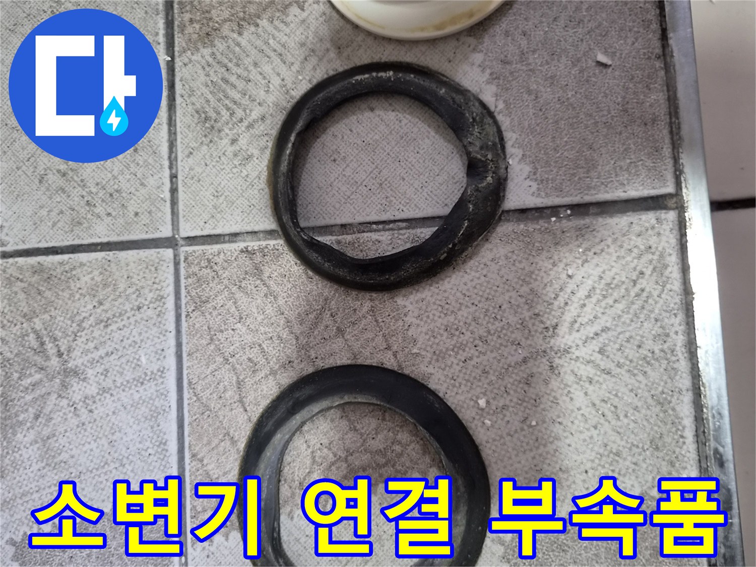 탈거된 검은색 고무 링과 백색 관 형태의 배관 자재입니다.