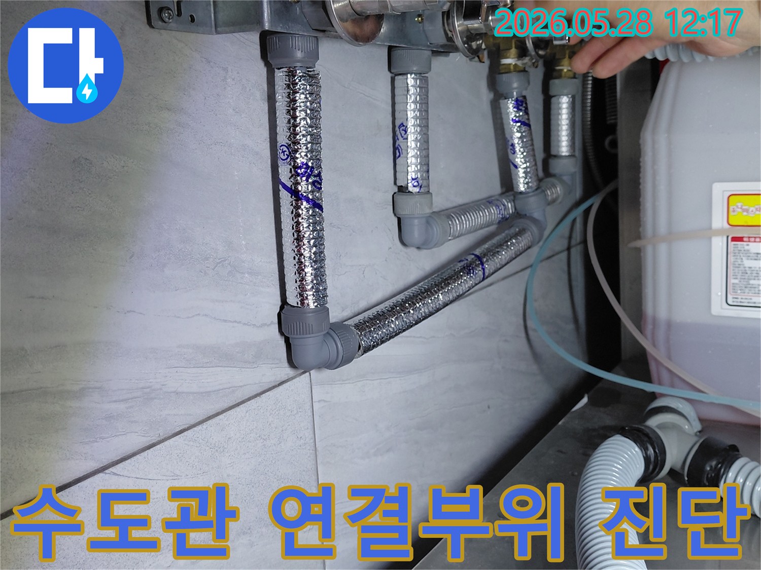 수도관의 다양한 연결 부위와 밸브를-전문가가 세심하게 진단하며 누수 흔적을 찾는 모습