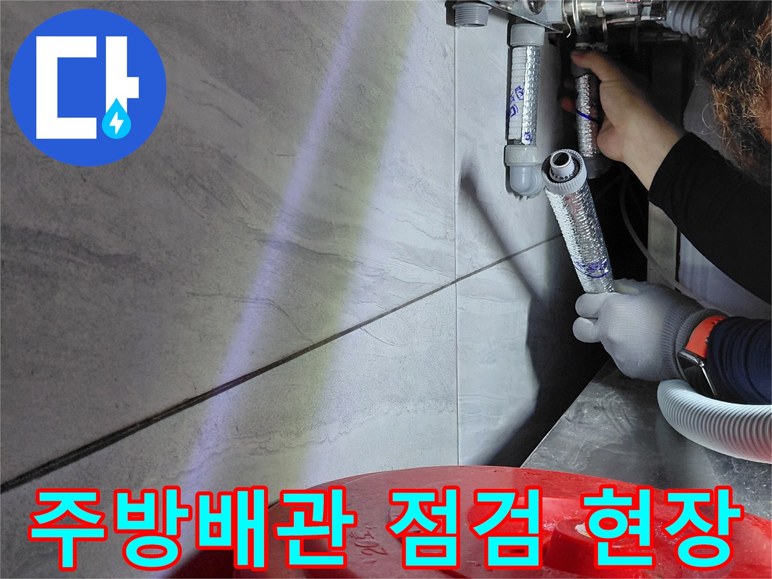 싱크대 하부 배관 연결 부위를 정밀하게 점현하는 모습