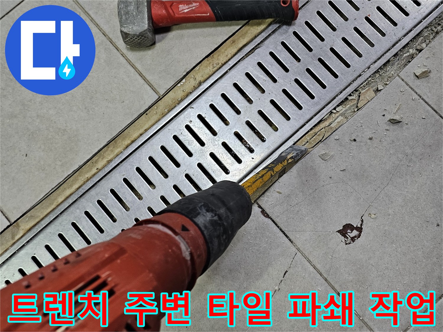 금속 트렌치 덮개 옆 타일을 깨뜨리는 공사 진행 상황