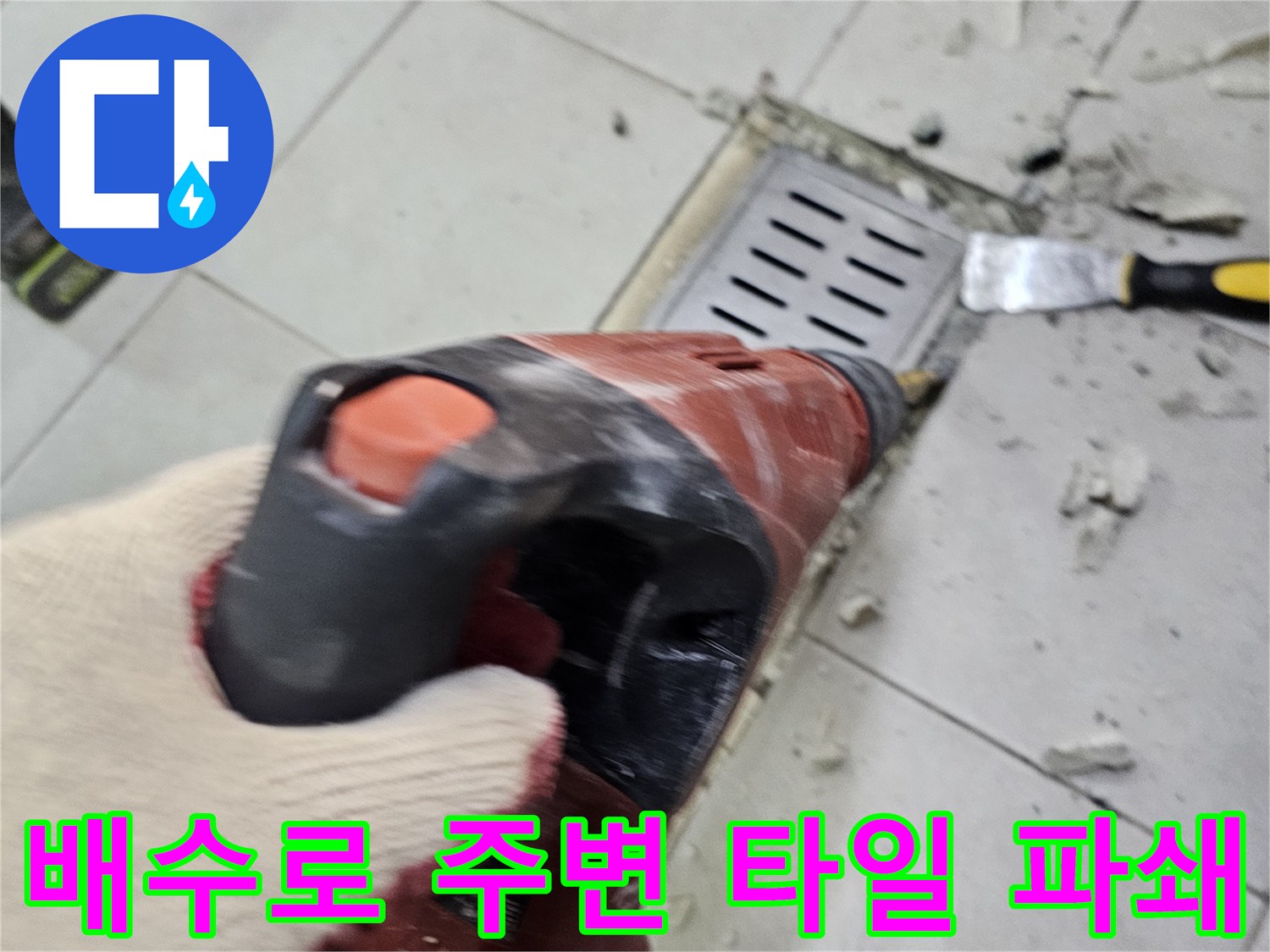 드릴 장비를 사용하여 트렌치 옆 타일을 걷어내는 작업자 손