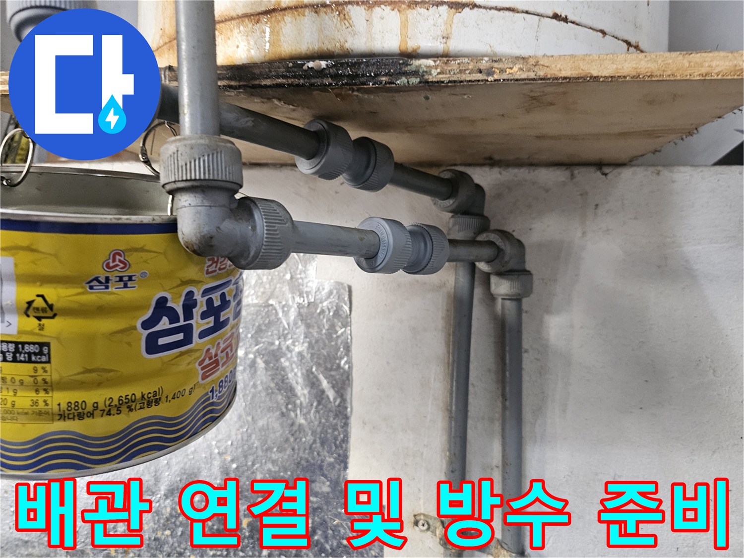 식당 주방 트렌치 주변의 노후 배관과 보수용 자재 배치