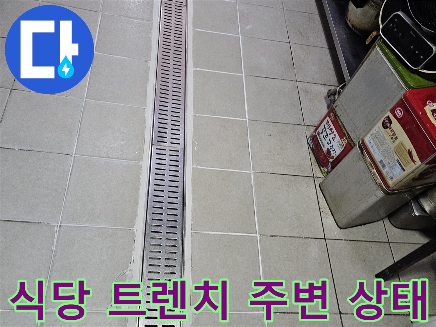 식당 주방의 스테인리스 배수 트렌치와 타일 접합부 모습