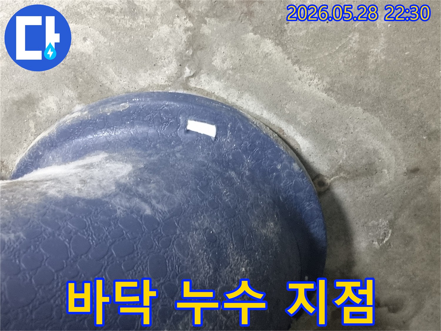 콘크리트 바닥의-파란색 배관-주변에서-물이-새어-나와-젖은-모습을-보여주는-바닥-누수-현장-사진