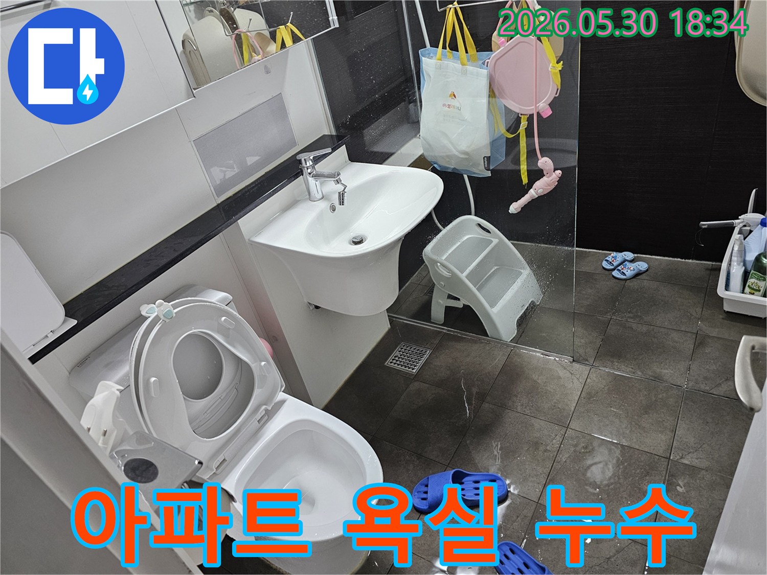 물이 고여있는 욕실 바닥-변기와 세면대 주변으로 퍼진 물-누수 진단이 시급한 상황