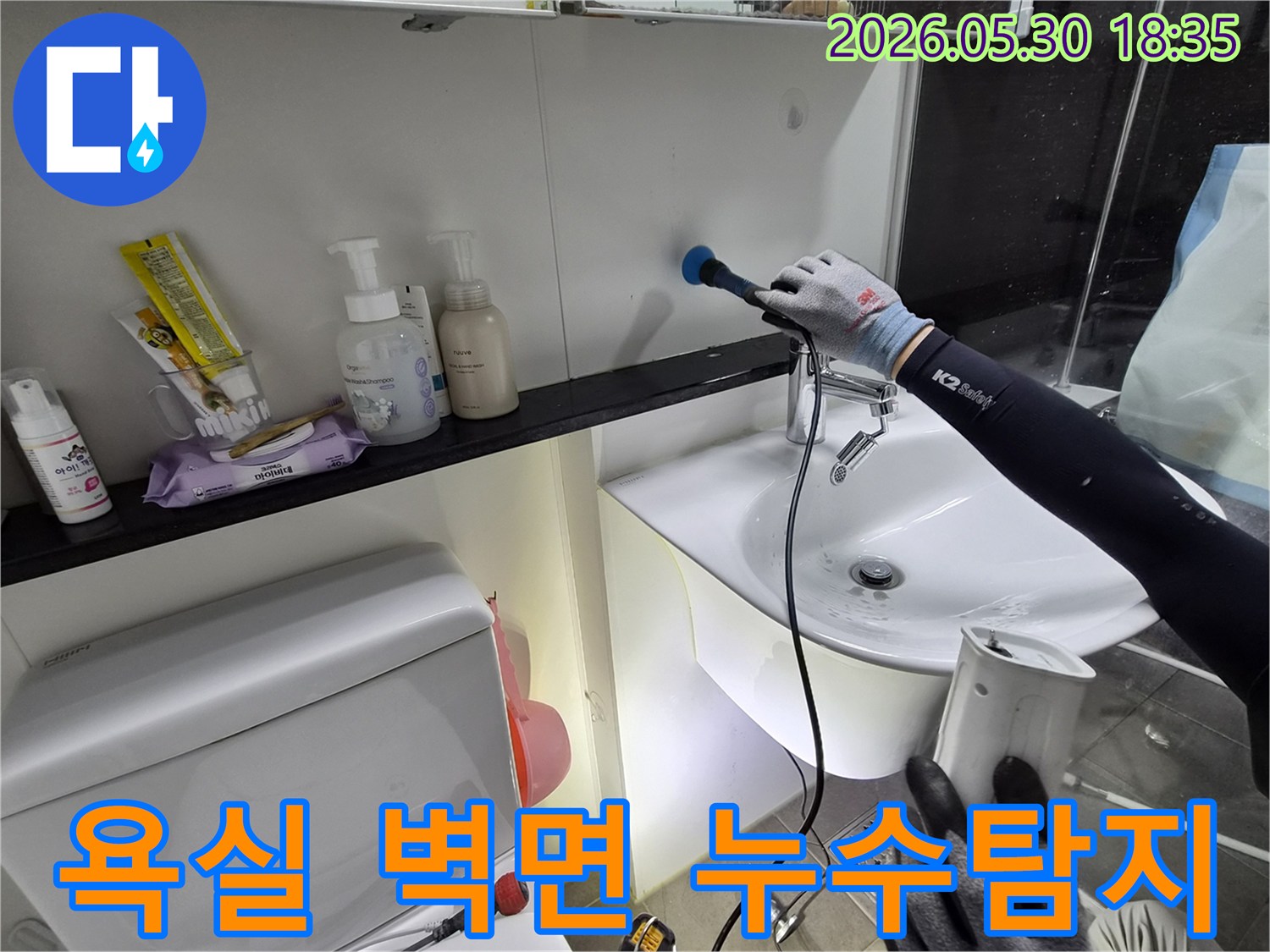 욕실-벽면의-숨겨진-누수-지점을-찾기-위해-전문-탐지-장비를-이용하여-정밀하게-조사하는-모습