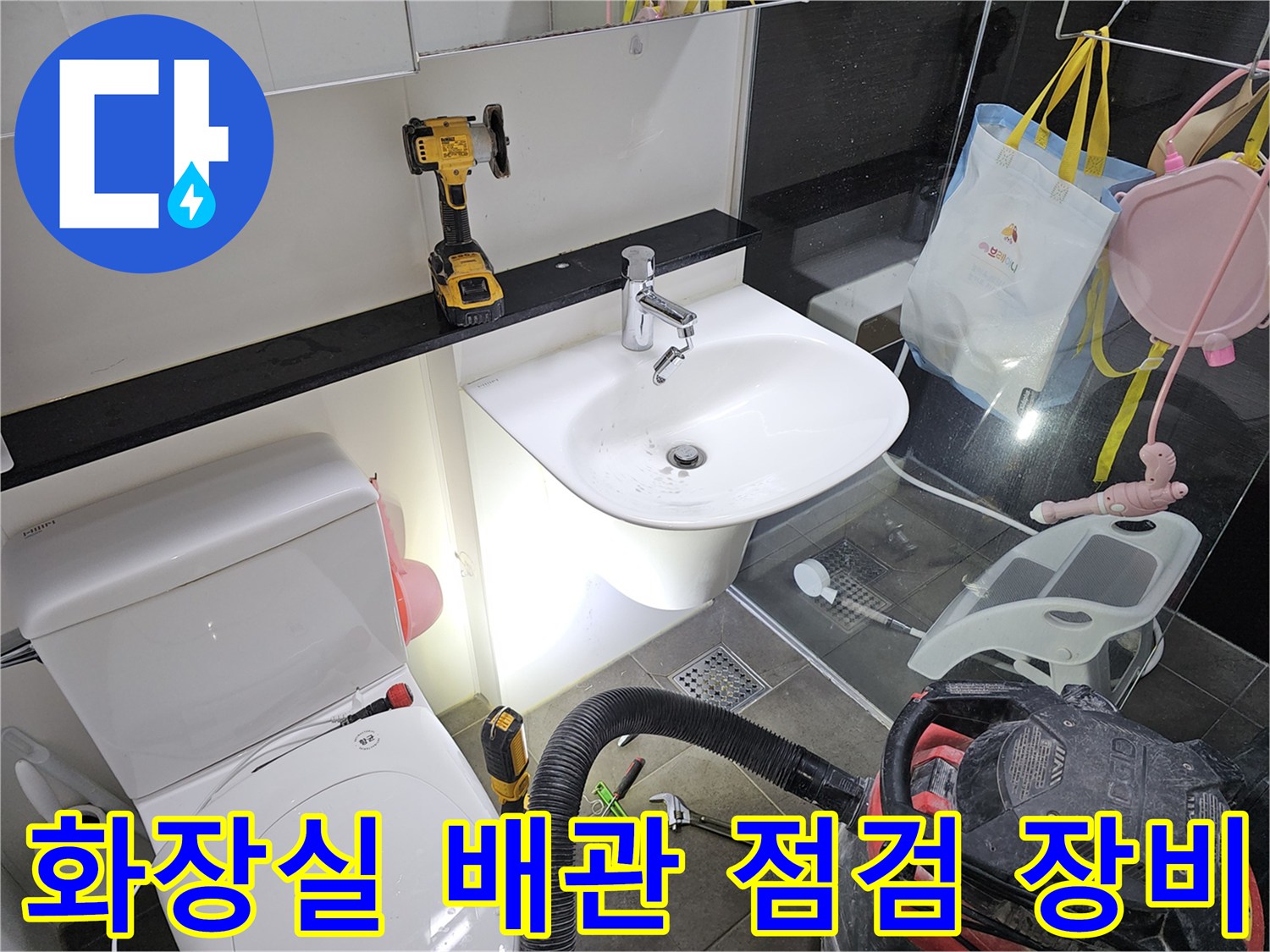 화장실 세면대 근처에 놓인 전동 드릴과 수리용 공구들