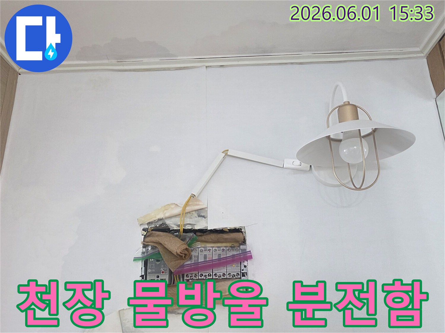 천장에서 물이 떨어져 분전함 주변이 젖어있는 모습으로-전기 합선 위험이 있어 즉각적인 조치가 필요한 상황입니다
