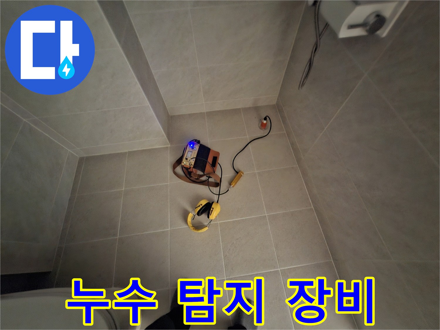 바닥 타일 위에 설치된 배관 누수 진단용 측정 기기