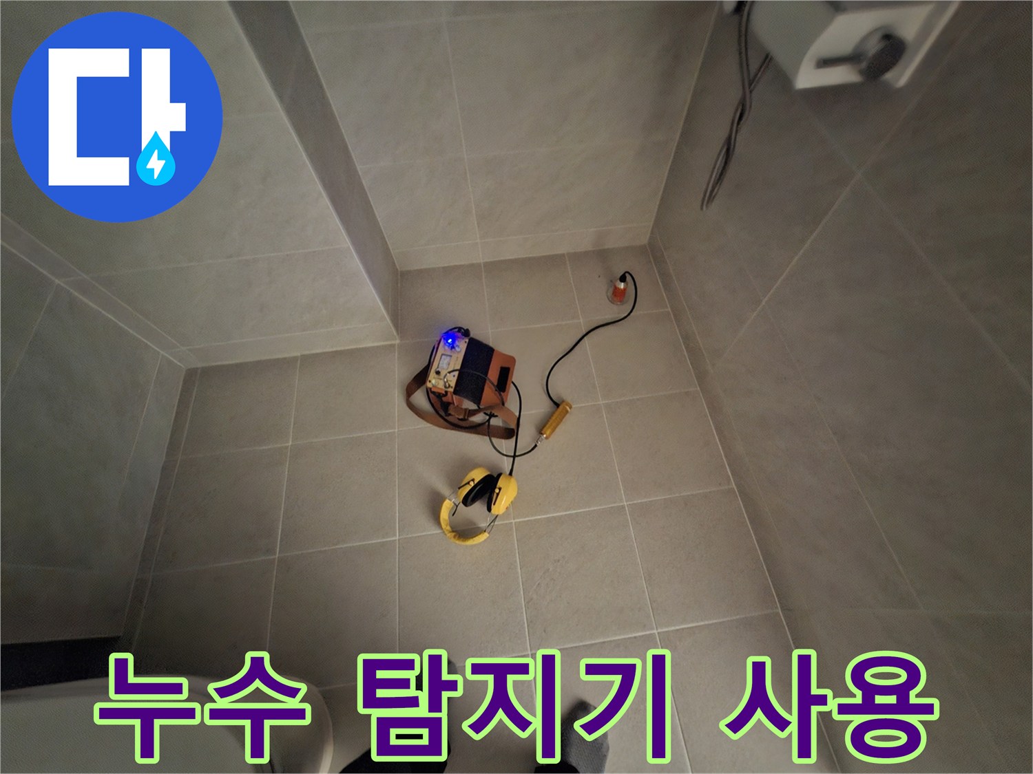 욕실 타일 바닥에 설치된 노란색 가스식 누수 탐지 장비