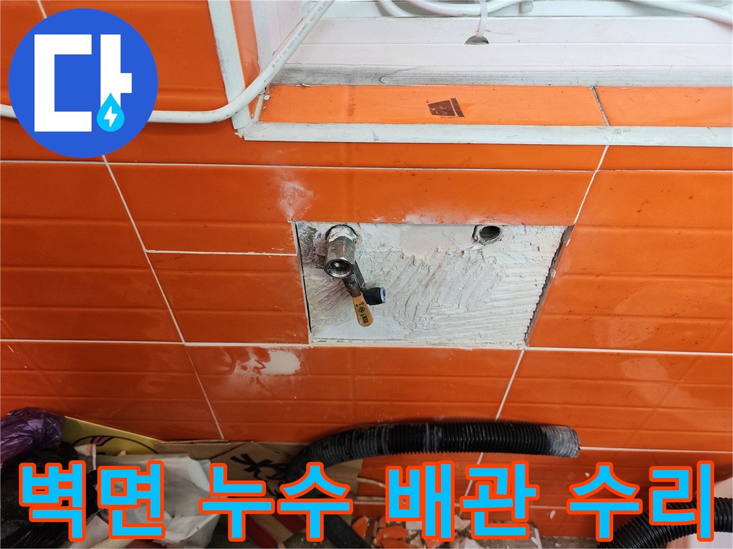 오렌지색 타일 벽면에서-누수 지점을 확인하고-수도 밸브를 수리하는 모습