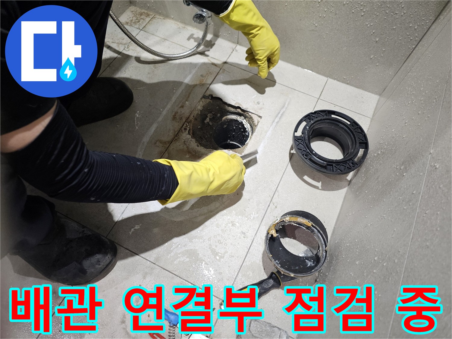 노란 장갑을 낀 작업자가 배관 누수 부위를 살피는 장면