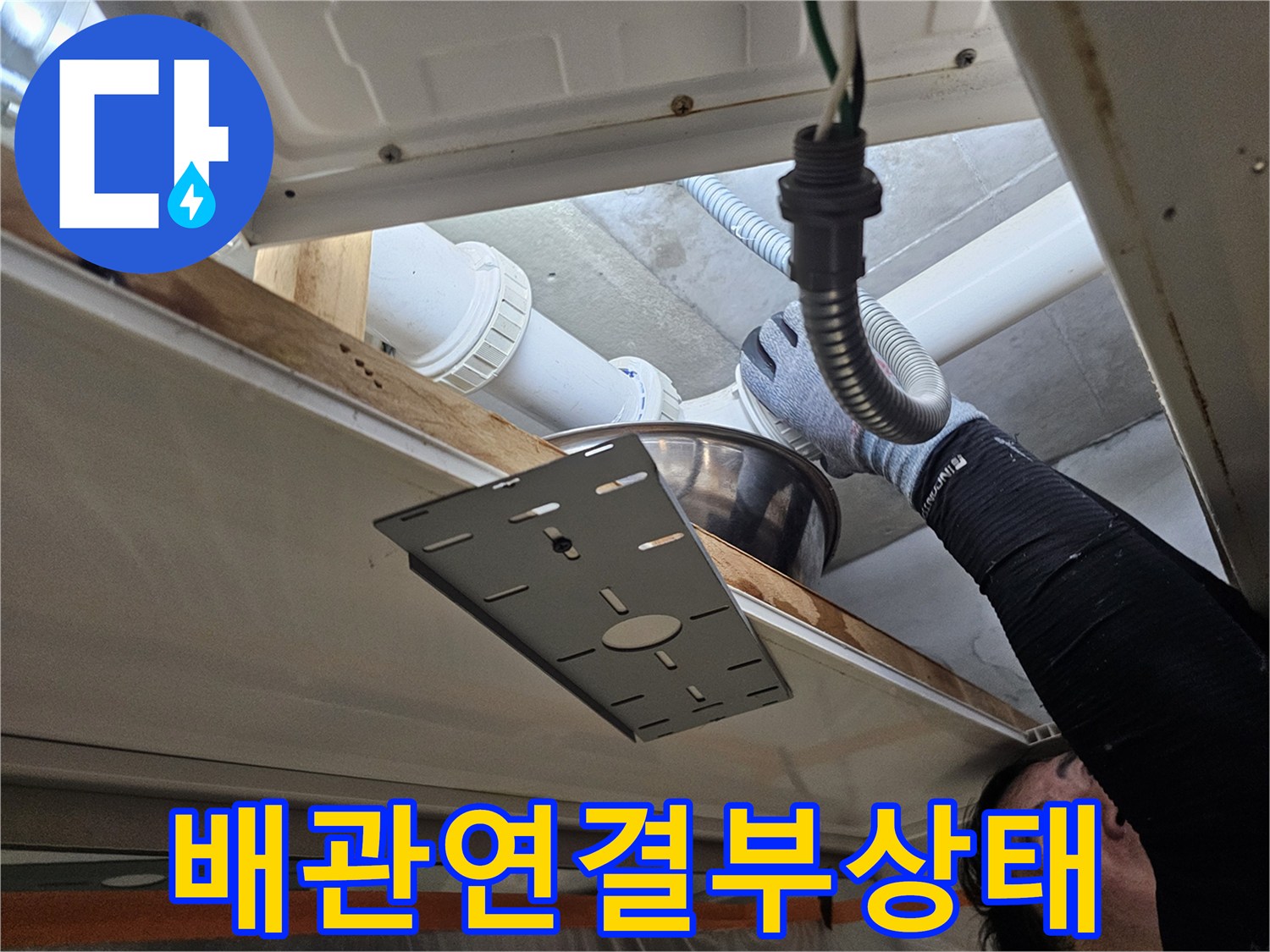 하수관 연결 부위 - 천장 내부의 배관 구조와 틈새를 확인 중인 장면입니다.