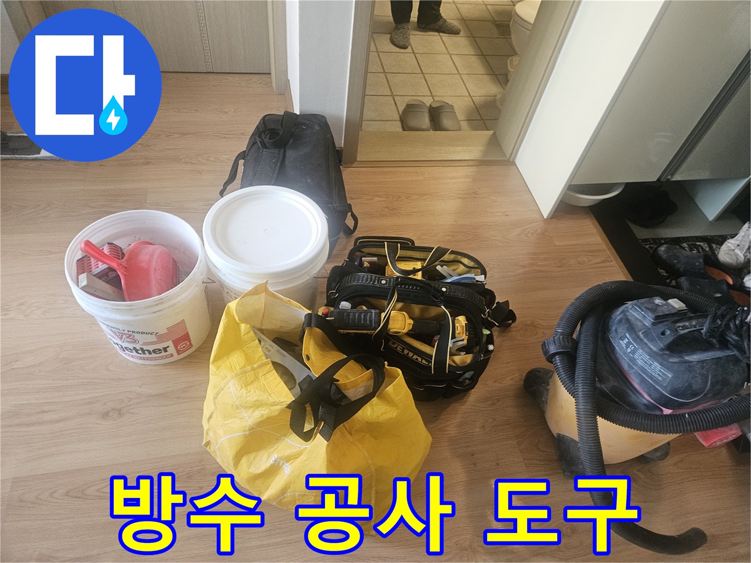 공사 현장에 놓인 청소기와 방수용 버킷 및 자재 가방