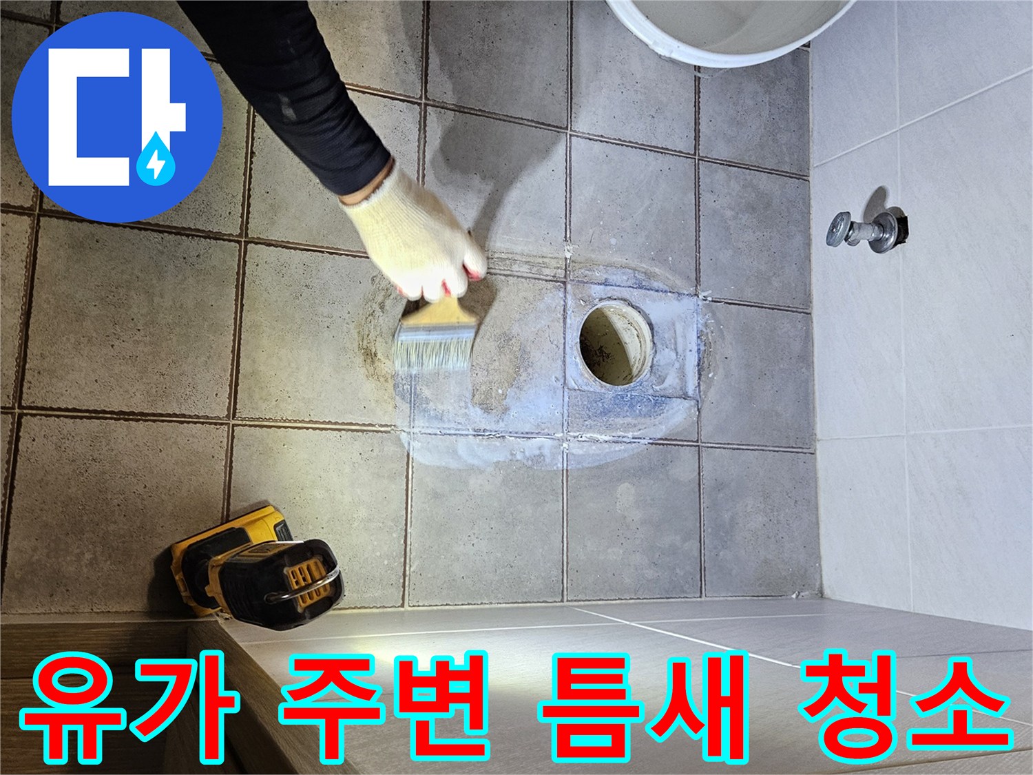 배관과 타일 사이의 찌꺼기를 제거하는 작업자 손
