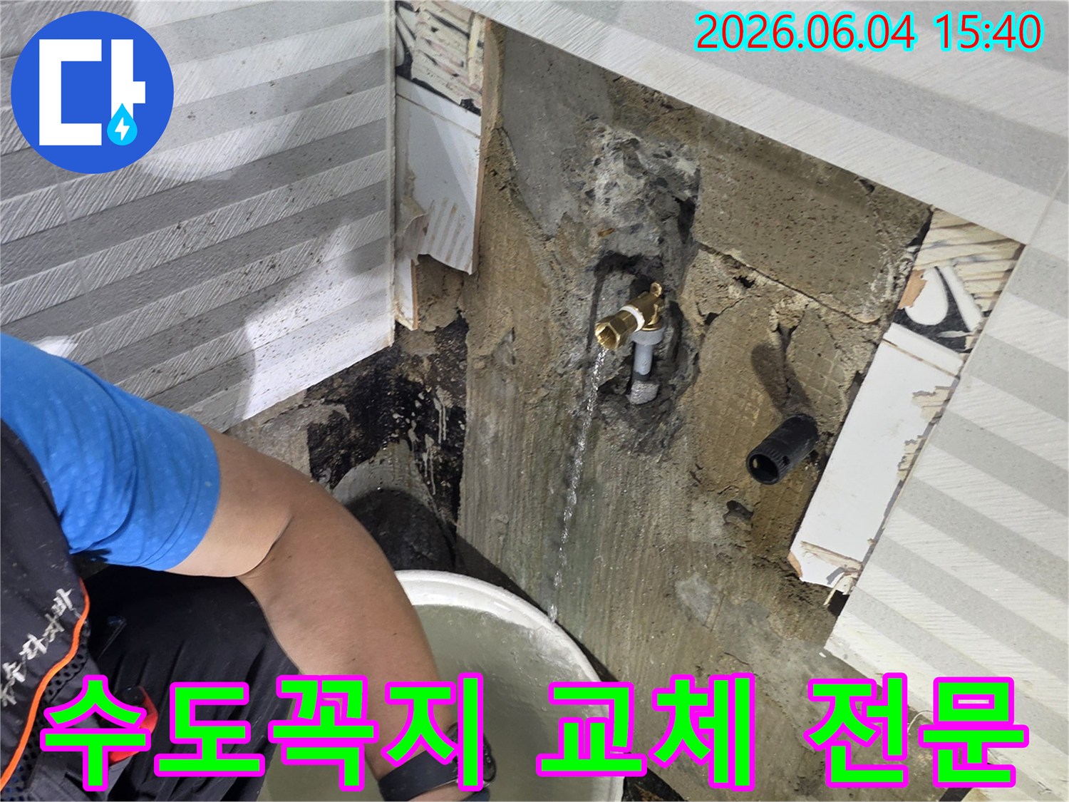 베란다 수도꼭지에서-물이 새는-현장에서-누수 전문가가-물을 받아내며-교체 작업을-준비하고 있습니다.