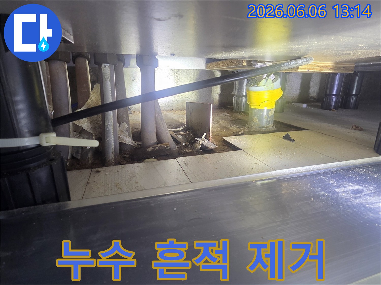 싱크대-아래-배관-주변의-누수-흔적을-제거하고-건조-작업을-진행하는-모습