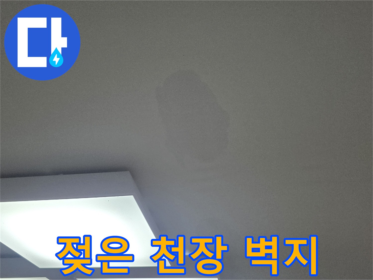 수분 침투로 인해 어둡게 변해버린 천장 벽지 부위