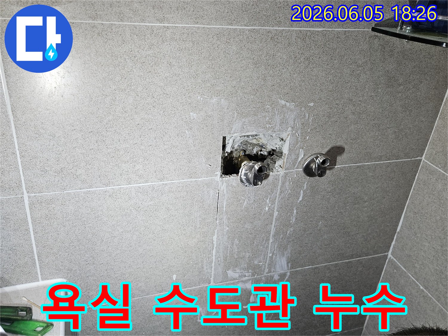 욕실 벽면 안쪽의 수도 배관에서 발생한 누수를-긴급하게 보수하고 있는 전문 기술자의 작업 현장