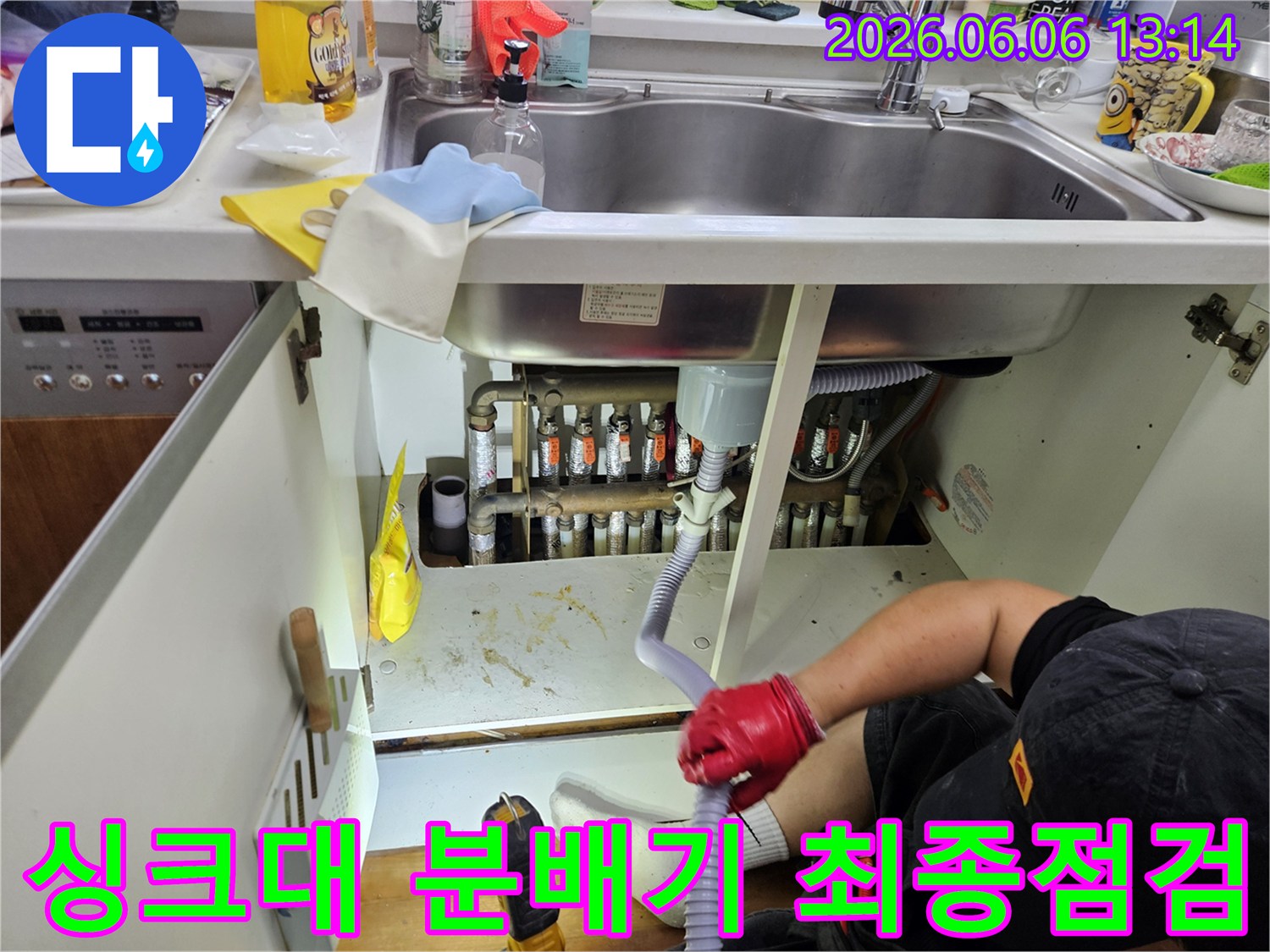 전문-엔지니어가-싱크대-아래-보일러-분배기-누수-수리-후-최종-점검과-테스트를-진행하고-있습니다
