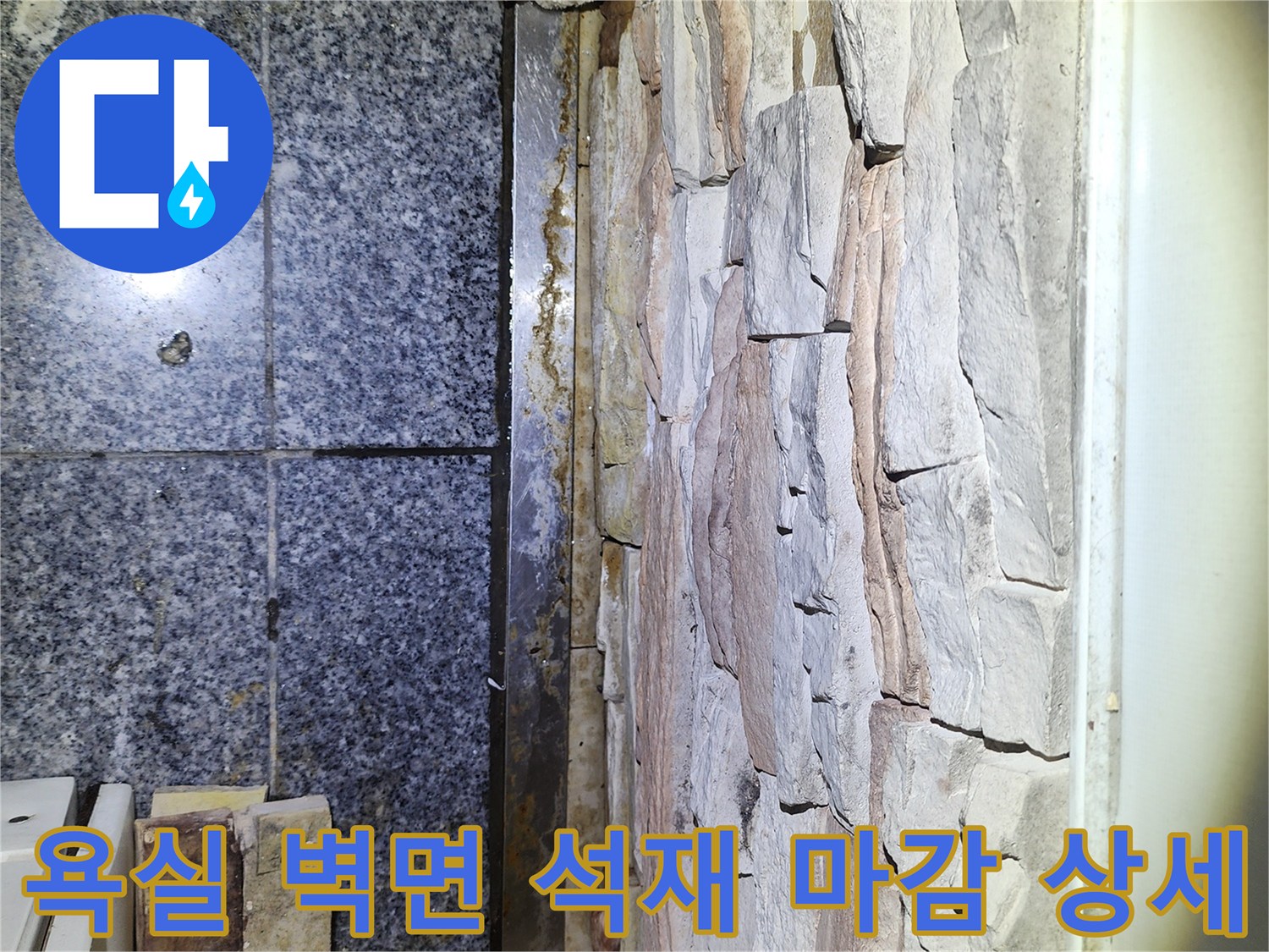 욕실 내부의 거친 질감의 석재 벽면과 하단 타일 경계 부분 사진입니다.