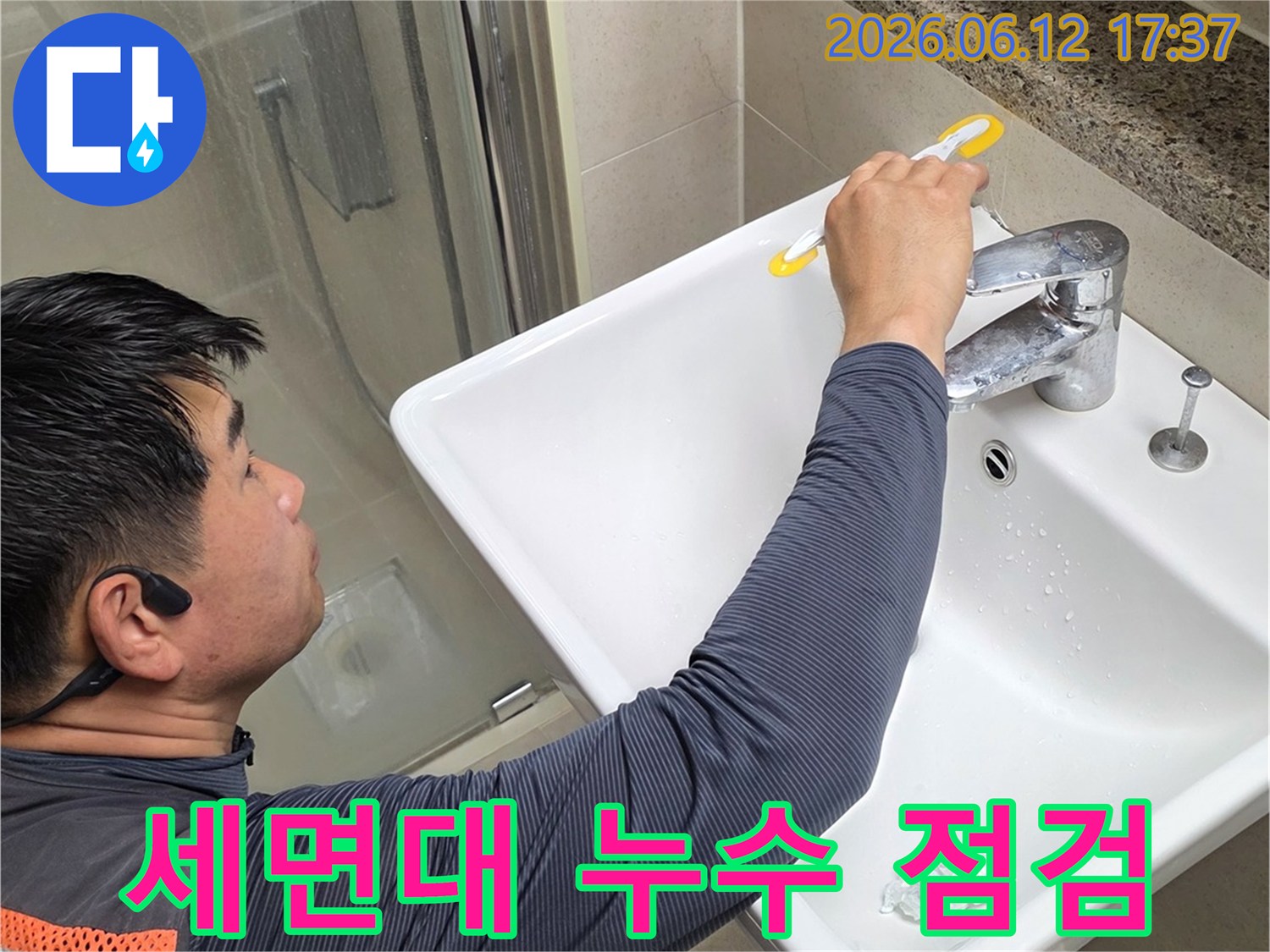 전문가가 세면대 아래쪽에서 발생할 수 있는-미세한 물샘 현상을-집중적으로 점검하는 모습입니다.