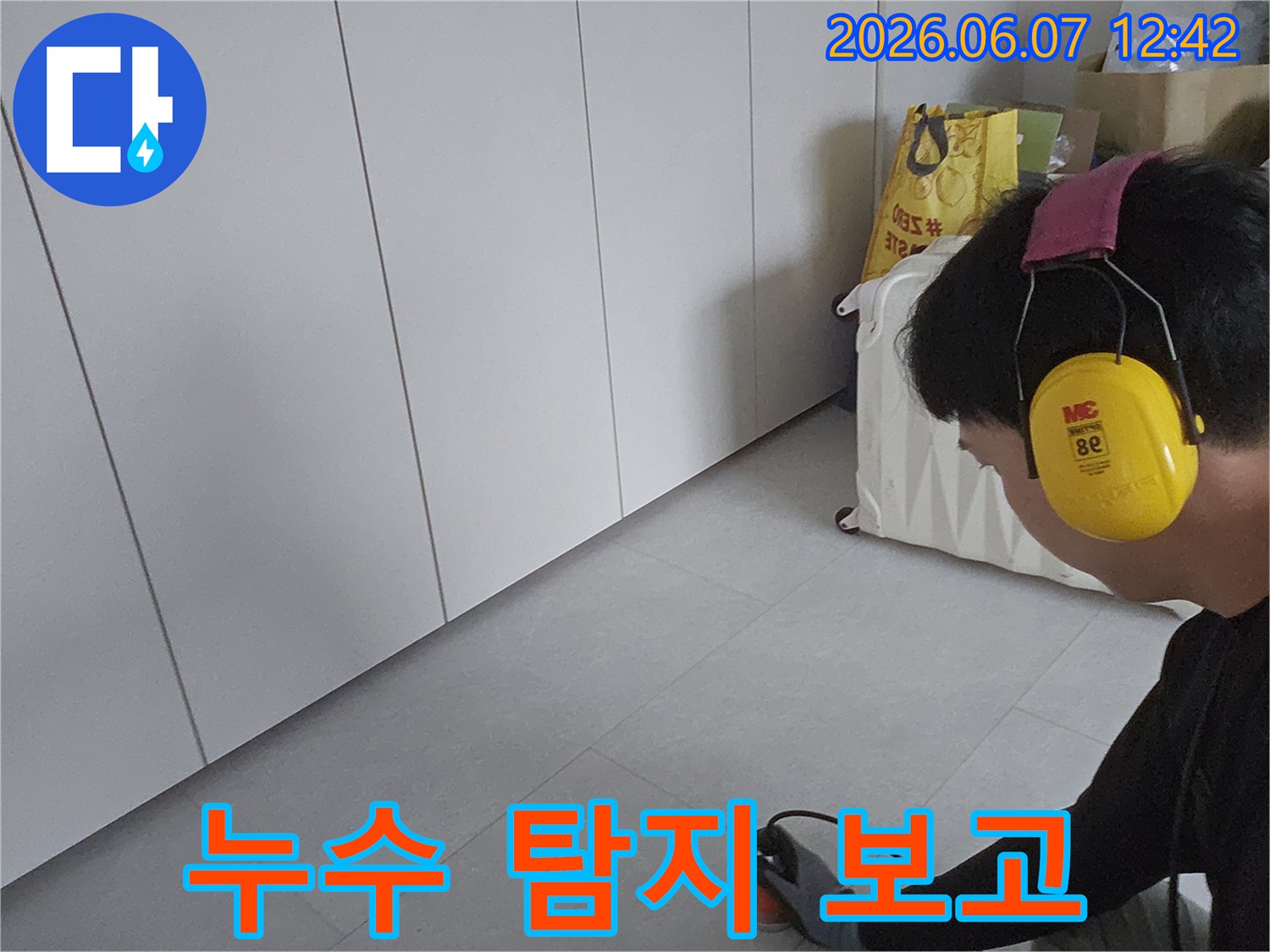 누수-엔지니어가-탐지-장비를-사용하여-누수-지점을-확인하고-고객에게-설명할-준비를-하는-모습