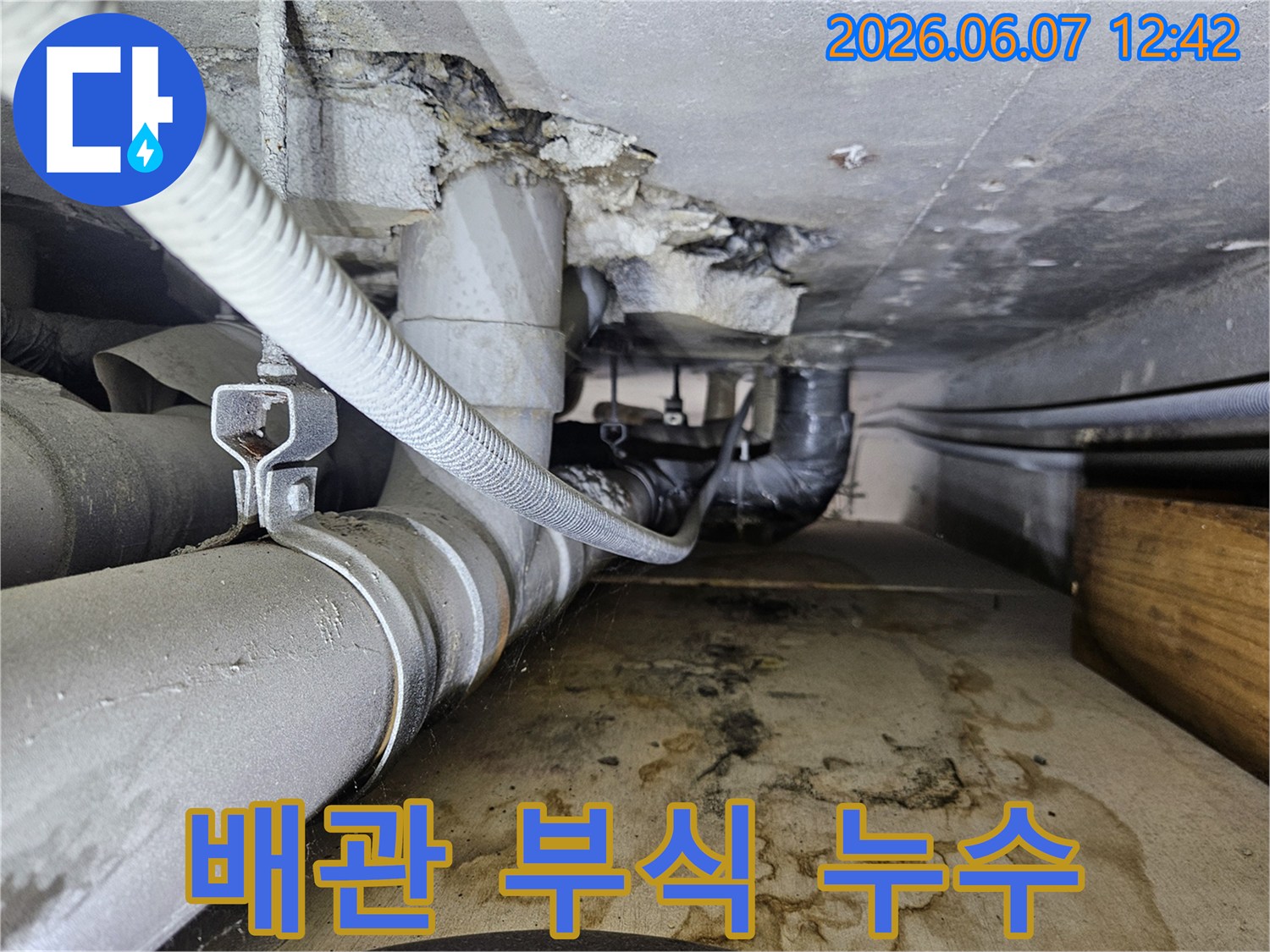 부식된 배관에서 물이 새어 나와-바닥에 물자국과-습기가 가득한-누수 현장의 모습입니다.