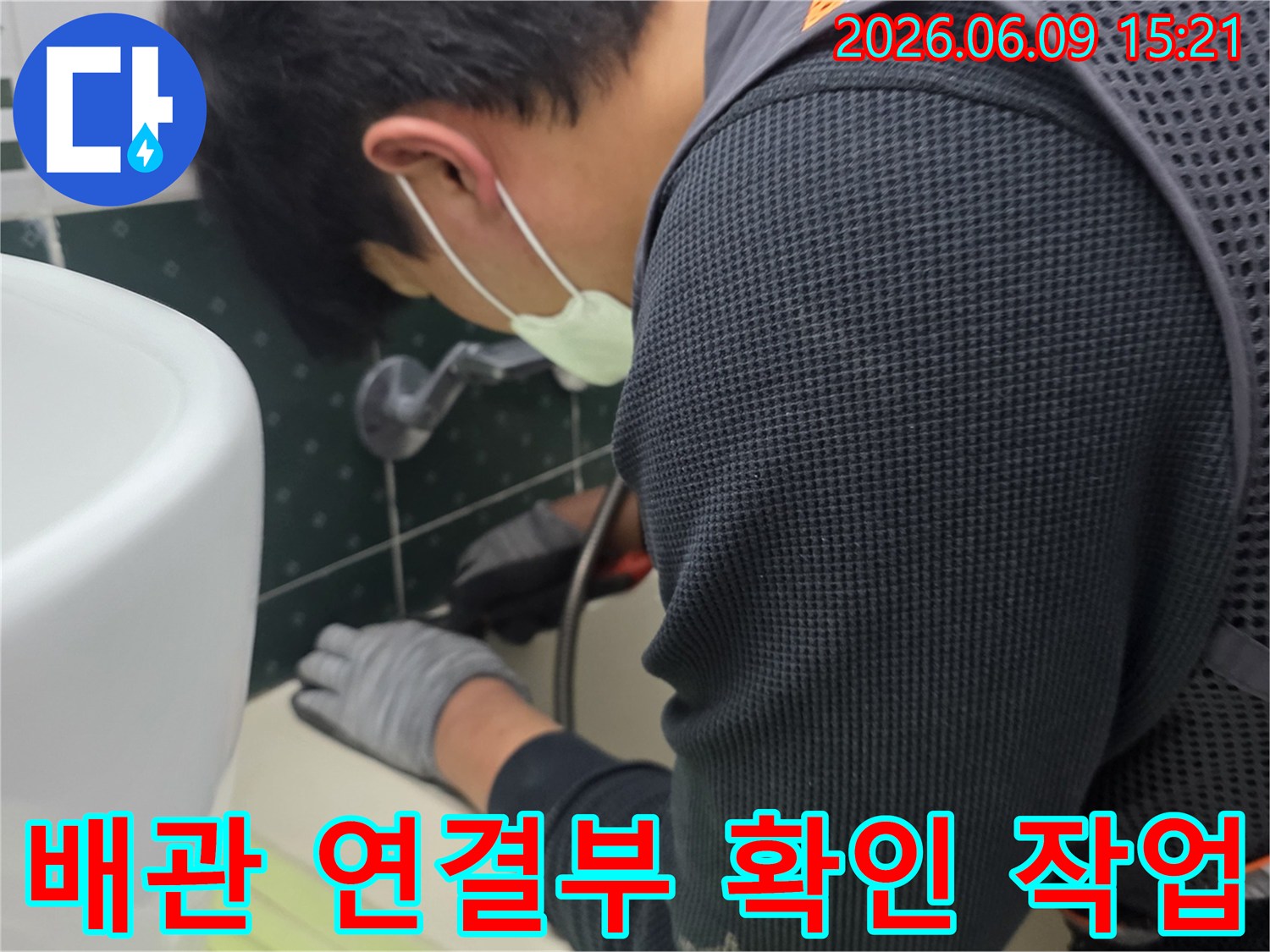 마스크를-착용한-전문가가-장갑을-끼고-화장실-배관의-연결-부위를-세심하게-확인하며-누수-여부를-점검하는-장면입니다.
