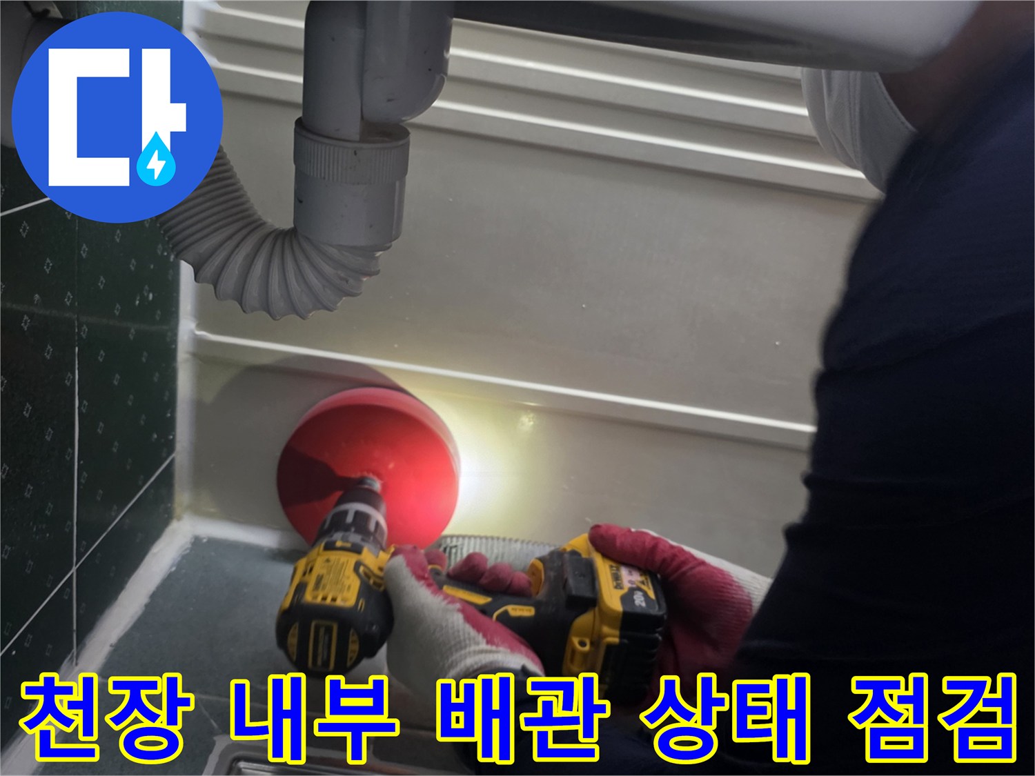 손전등 불빛으로 배관 연결부를 비추며 누수를 찾는 과정