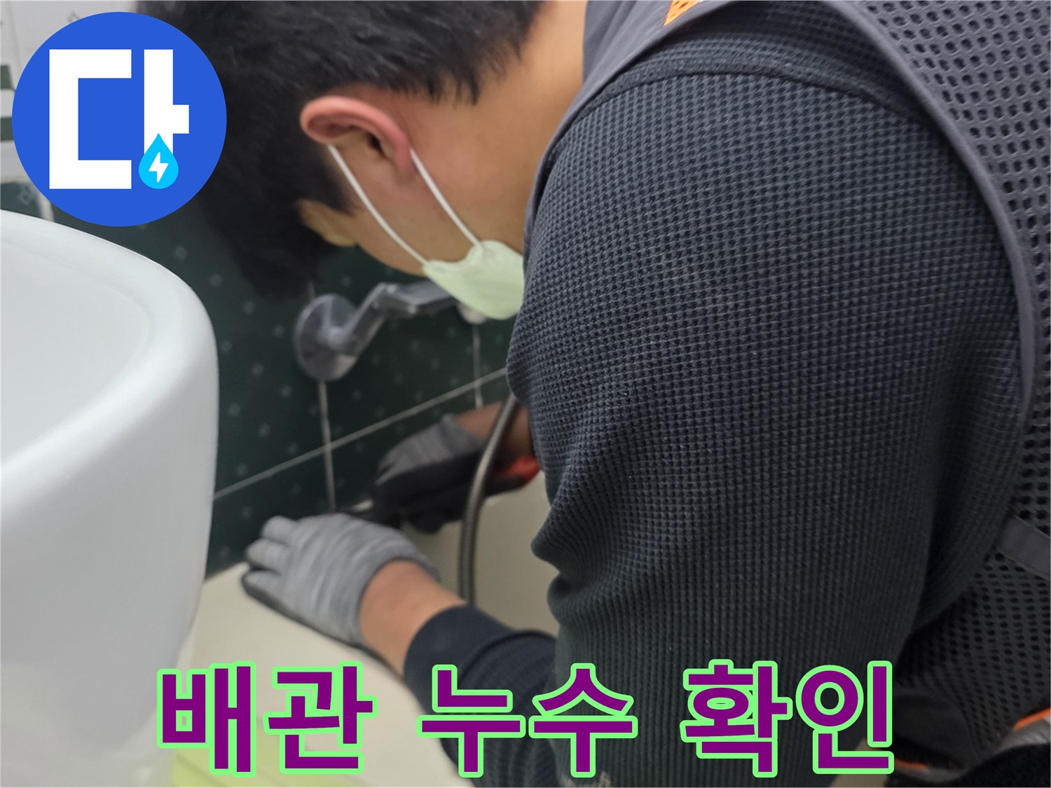 점검구 안쪽 배관 부위를 손으로 가리키며 점검하는 모습