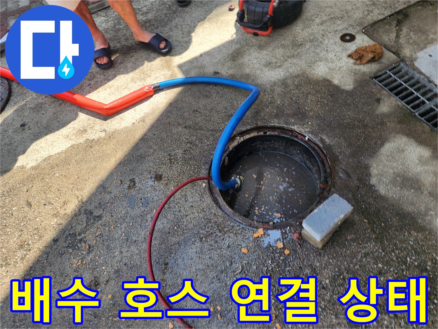 오수받이-맨홀에-연결된-주황색과-파란색-배수-호스