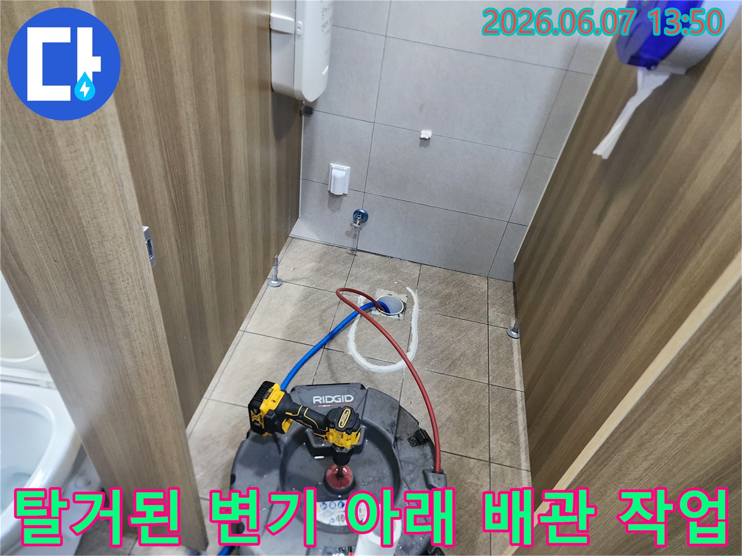 변기를 분리한 후 노출된 오수관 입구에 샤프트 장비를 연결하여 작업을 수행 중입니다.