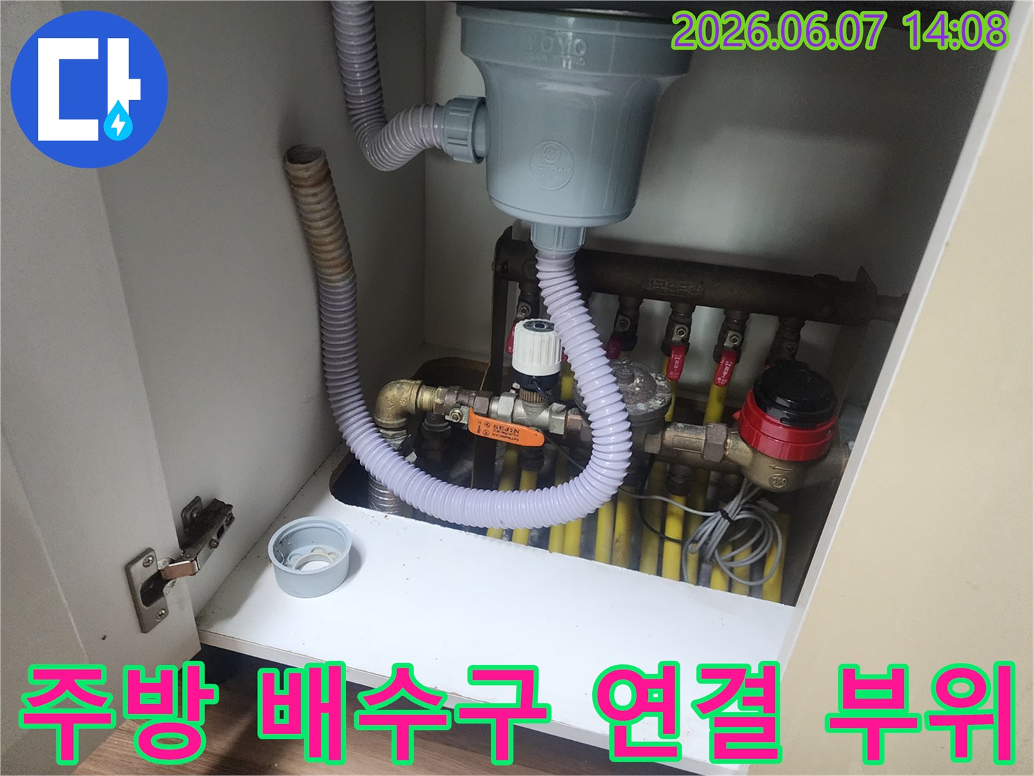 싱크대 하단 배수 호스와 여러 개의 급수 밸브가 복잡하게 얽혀 있는 현장 사진입니다.