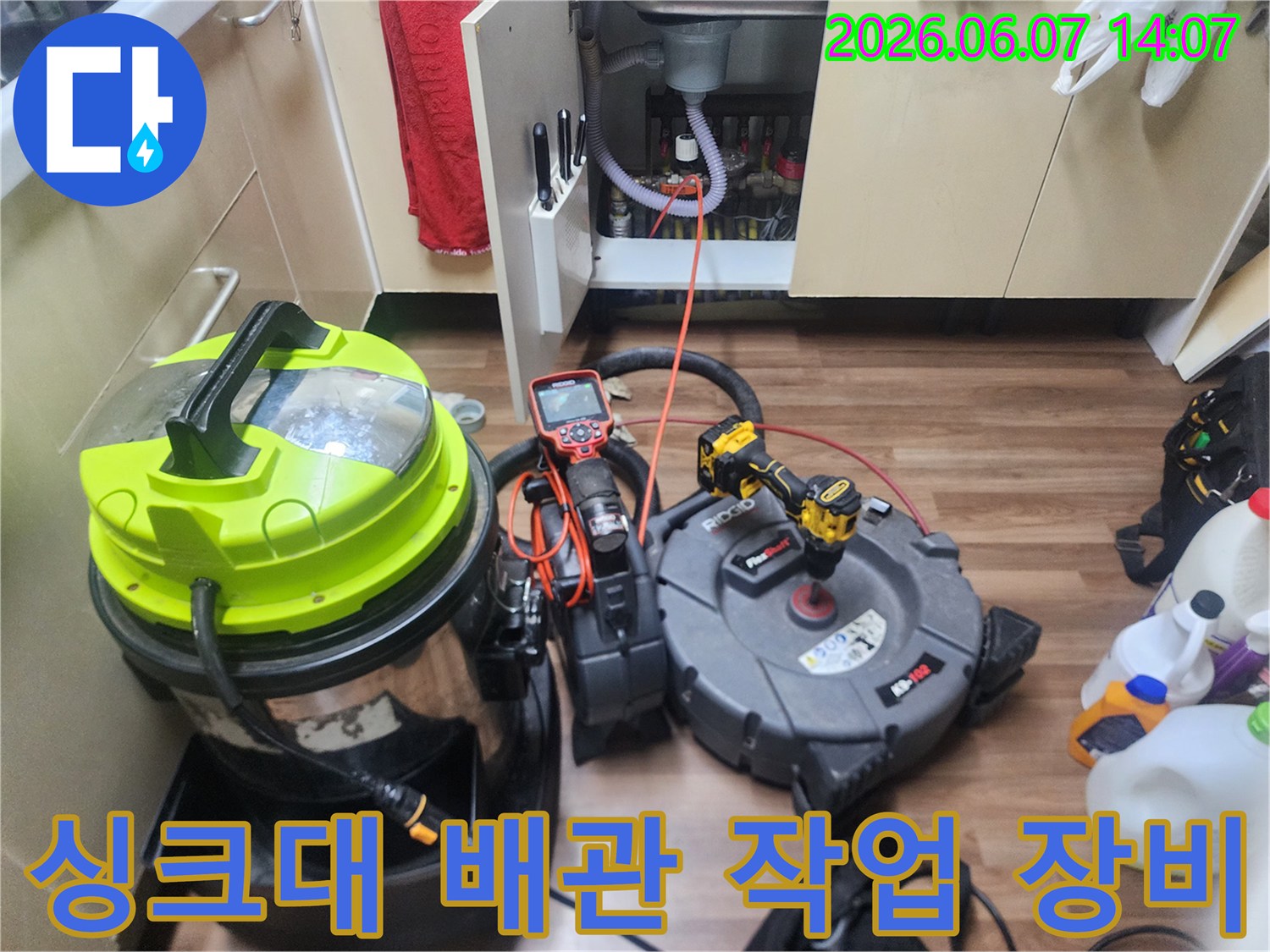 싱크대 하부장 아래에 놓인 플렉스 샤프트와 청소용 진공 흡입기 장비 세트