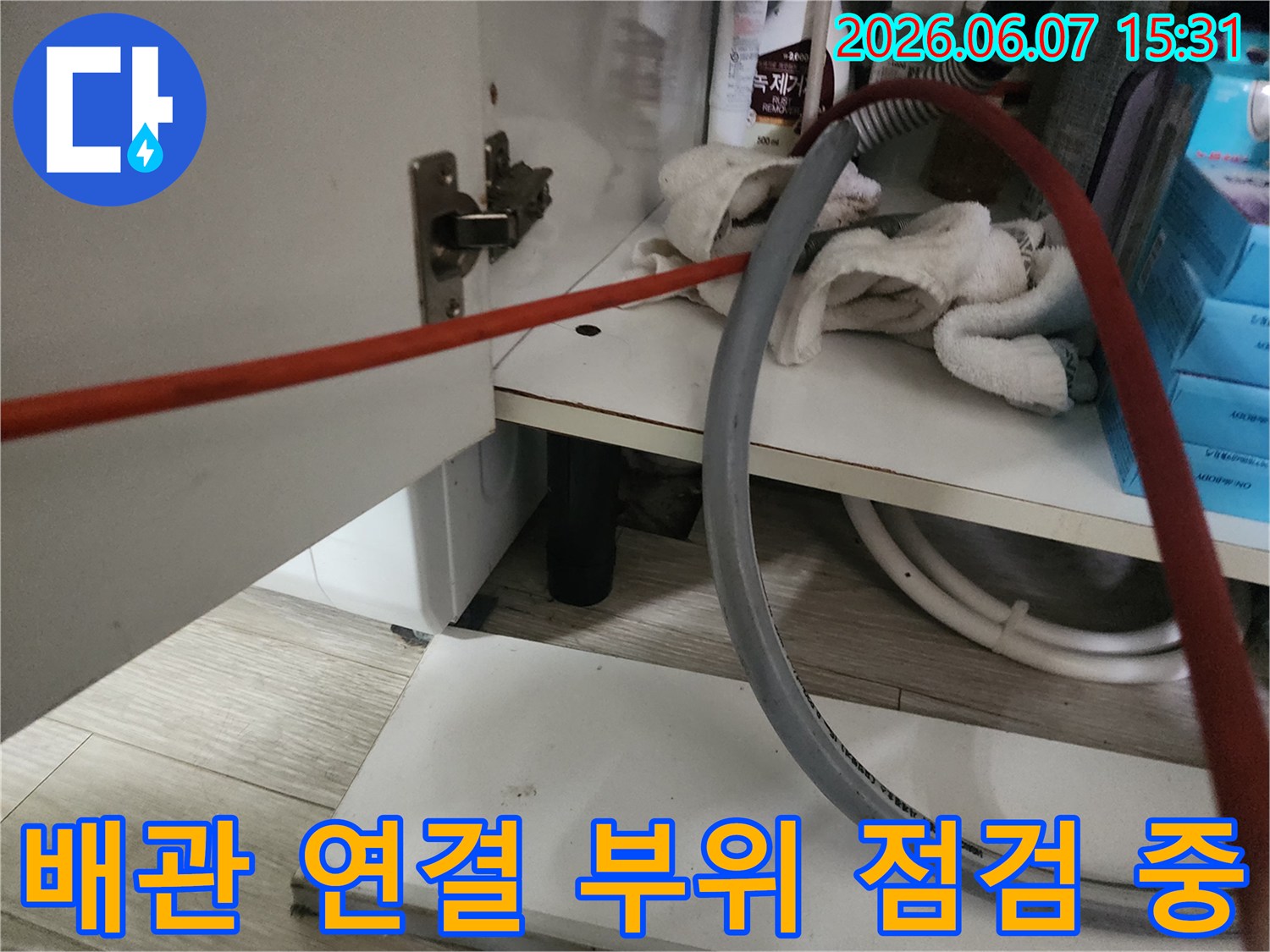 싱크대 하부장 배관의 연결 상태를 확인하는 장면입니다.