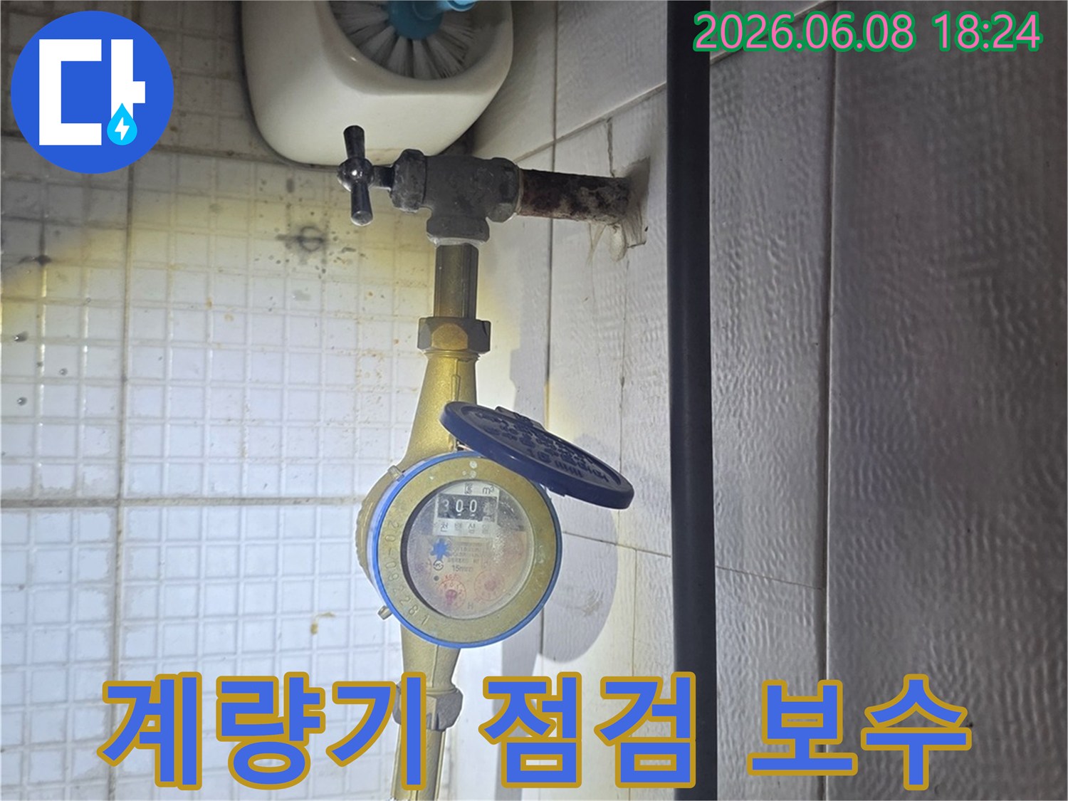 이 사진은-의정부 용민로의-한 아파트에서-누수 엔지니어가-수도 계량기 주변을-점검하고-필요한 보수를-진행하는-모습을-보여줍니다