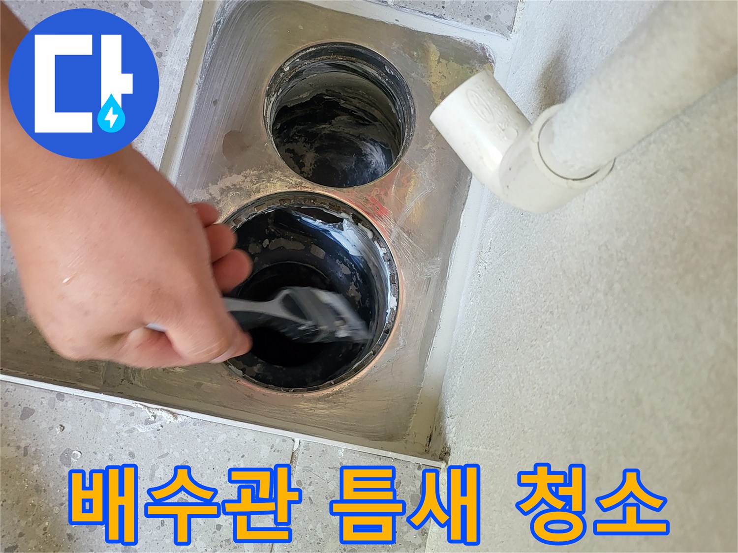 배수구-내부의-오염물질을-브러시로-닦아내는-작업-현장