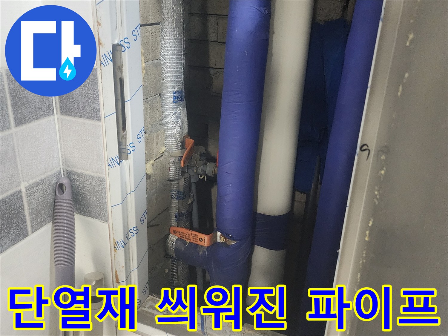 파란색 보온재로 마감된 배관과 금속 밸브의 근접 촬영