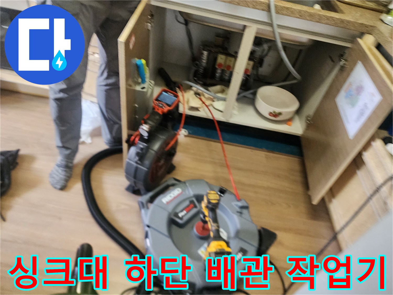 싱크대 하부장 내부 배관 청소를 위해 배치된 전문 장비들